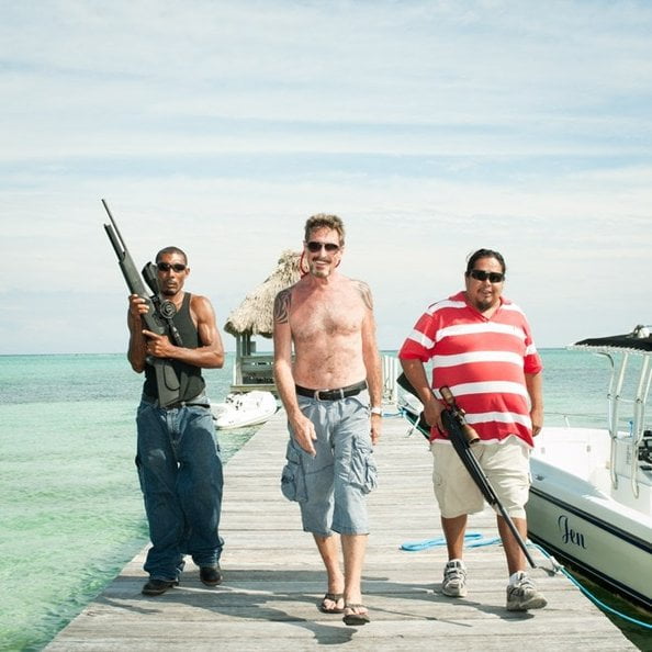 John McAfee em Belize com dois homens armados